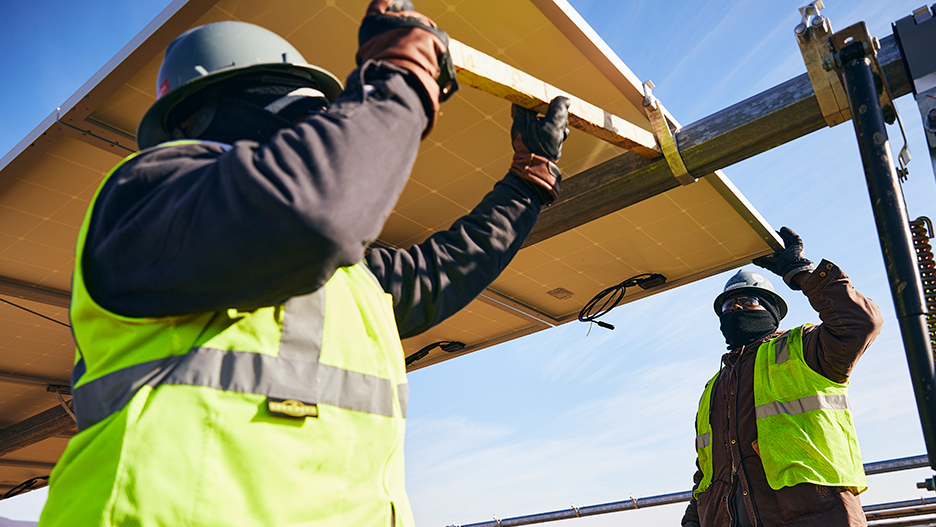 Construction workers putting up solar panels